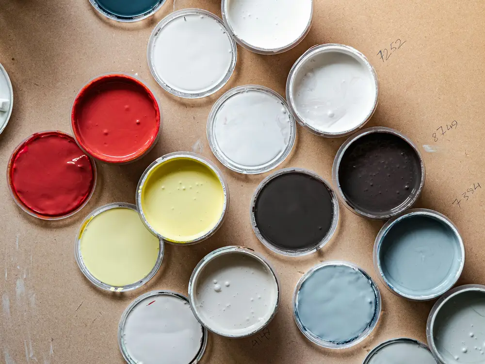 Open paint sample pots in blues, whites, reds and yellows
